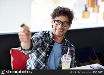 leisure, people, payment and finance concept - happy man paying with credit card at cafe