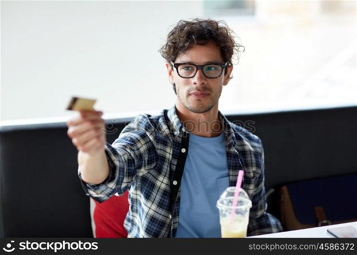 leisure, people, payment and finance concept - happy man paying with credit card at cafe