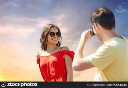 leisure, photography, summer holidays and people concept - happy couple with camera photographing over sky background. happy couple with camera photographing. happy couple with camera photographing