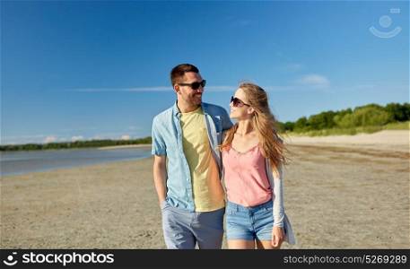 leisure, relationship and people concept - happy couple in sunglasses hugging on summer beach. happy couple hugging on summer beach