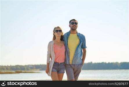 leisure, relationship and people concept - happy couple in sunglasses hugging on summer beach. happy couple in sunglasses hugging on summer beach
