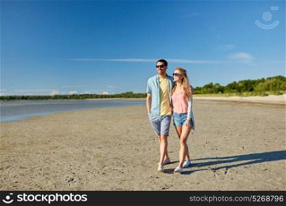 leisure, relationship and people concept - happy couple in sunglasses walking along summer beach. happy couple walking along summer beach