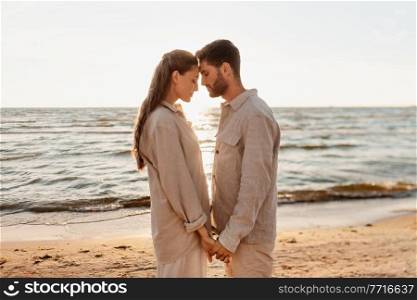 leisure, relationships and people concept - happy couple holding hands on summer beach. happy couple holding hands on summer beach