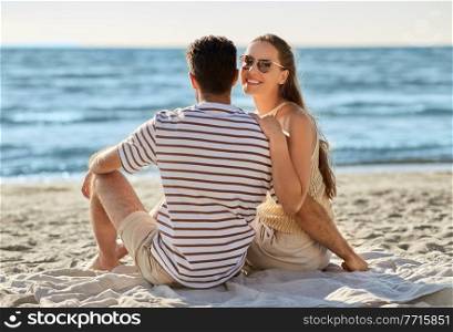leisure, relationships and people concept - happy couple in sunglasses hugging on summer beach. happy couple hugging on summer beach