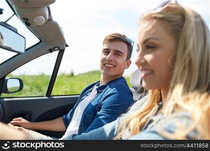 leisure, road trip, travel and people concept - happy couple driving in cabriolet car outdoors