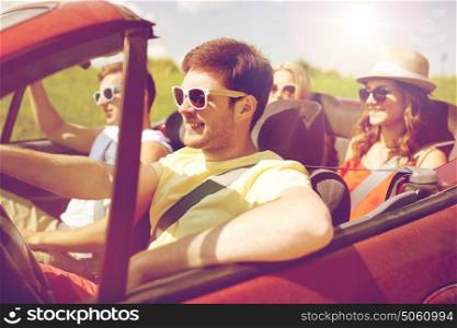 leisure, road trip, travel and people concept - happy friends driving in cabriolet car along country road. happy friends driving in cabriolet car