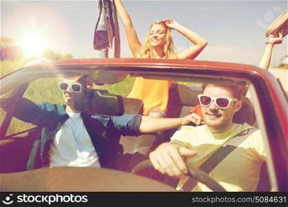 leisure, road trip, travel and people concept - happy friends driving in cabriolet car along country road. happy friends driving in cabriolet car. happy friends driving in cabriolet car