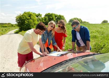 leisure, road trip, travel and people concept - happy friends with map and car at country searching for location