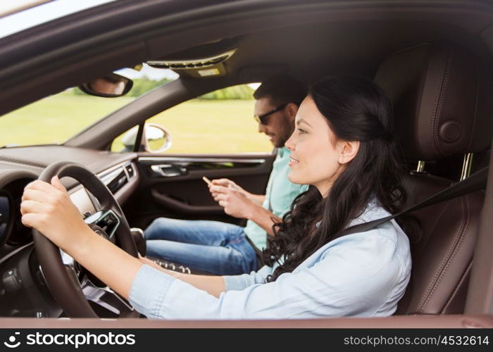 leisure, road trip, travel and people concept - happy man and woman driving in car