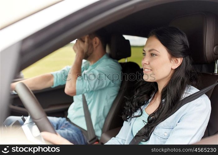 leisure, road trip, travel and people concept - woman driving car and man covering face with his palm