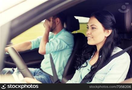 leisure, road trip, travel and people concept - woman driving car and man covering face with his palm. woman driving car and man covering face with palm