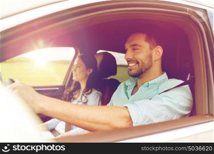 leisure, road trip, travel, family and people concept - happy man and woman driving in car. happy man and woman driving in car