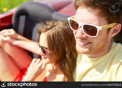 leisure, road trip, travel, summer holidays and people concept - happy couple driving in cabriolet car and hugging