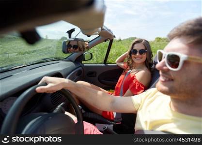 leisure, road trip, travel, summer holidays and people concept - happy couple driving in cabriolet car at country