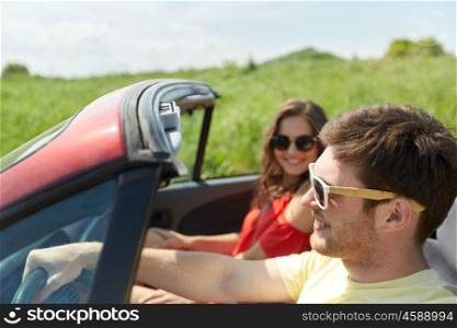 leisure, road trip, travel, summer holidays and people concept - happy couple driving in cabriolet car at country