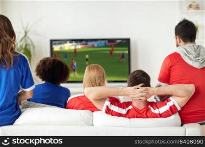 leisure, sport and entertainment concept - friends or football fans watching soccer game on tv at home. friends or soccer fans watching game on tv at home