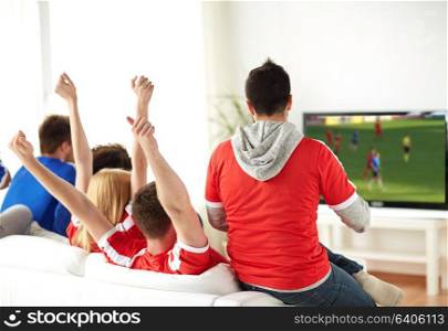 leisure, sport and entertainment concept - happy friends or football fans watching soccer game on tv and celebrating victory at home. friends or soccer fans watching game on tv at home