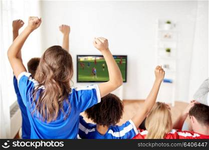 leisure, sport and entertainment concept - happy friends or football fans watching soccer game on tv and celebrating victory at home. friends or soccer fans watching game on tv at home