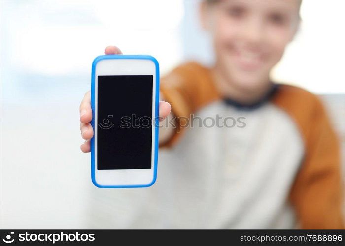leisure, technology and childhood concept - close up of boy with smartphone at home. close up of boy with smartphone at home