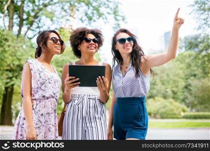 leisure, technology and friendship concept - happy women or friends with tablet pc computer on street in summer. women with tablet computer on street in summer