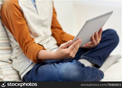 leisure, technology and people concept - close up of boy with tablet pc computer at home. close up of boy with tablet pc computer at home