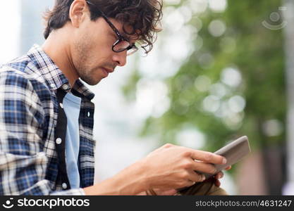 leisure, technology, communication and people concept - close up of creative man with tablet pc computer on city street