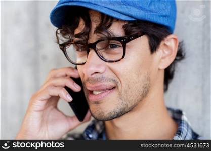 leisure, technology, communication and people concept - close up of hipster man in hat and glasses calling on smartphone