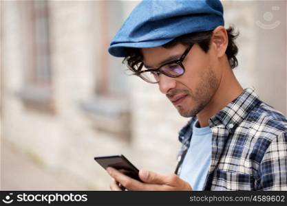 leisure, technology, communication and people concept - close up of hipster man texting message on smartphone