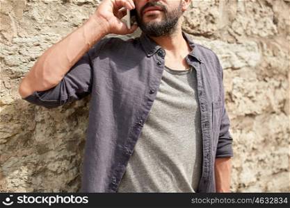 leisure, technology, communication and people concept - close up of man calling and talking on smartphone on street