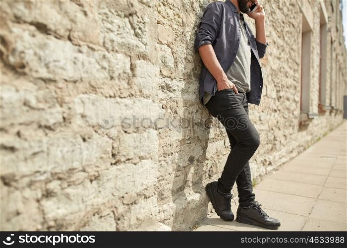 leisure, technology, communication and people concept - close up of man calling and talking on smartphone on street