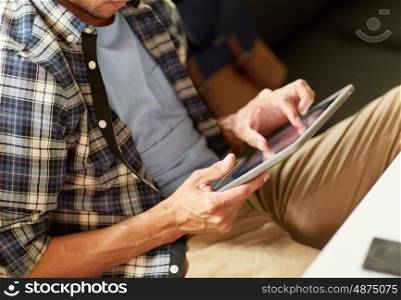 leisure, technology, communication and people concept - close up of man with tablet pc computer sitting at cafe table