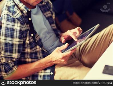 leisure, technology, communication and people concept - close up of man with tablet pc computer sitting at cafe table. close up of man with tablet pc sitting at cafe