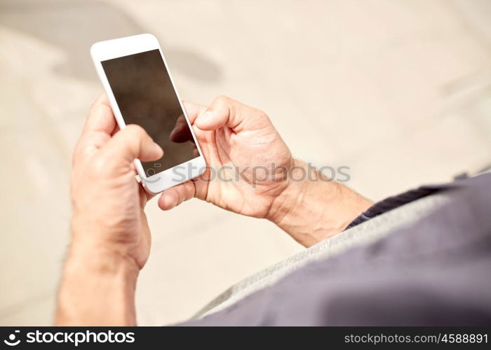 leisure, technology, communication and people concept - close up of man with smartphone on street