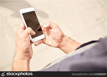 leisure, technology, communication and people concept - close up of man with smartphone on street