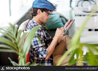 leisure, technology, communication and people concept - creative man with tablet pc computer sitting at cafe table