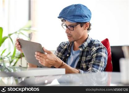 leisure, technology, communication and people concept - creative man with tablet pc computer sitting at cafe table
