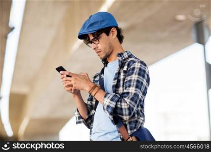 leisure, technology, communication and people concept - hipster man texting message on smartphone or playing augmented reality game