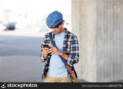 leisure, technology, communication and people concept - hipster man texting message on smartphone