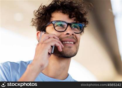 leisure, technology, communication and people concept - man in eyeglasses calling on smartphone on street