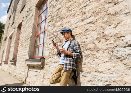 leisure, technology, communication and people concept - man with smartphone drinking coffee from disposable paper cup and texting message on city street