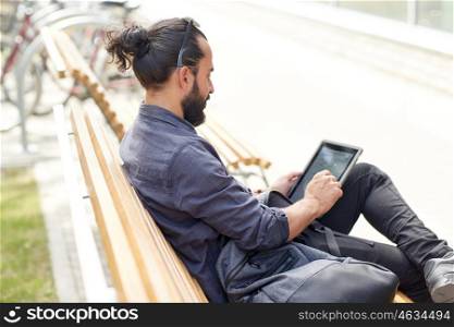 leisure, technology, communication and people concept - man with tablet pc computer and bag sitting on city street bench