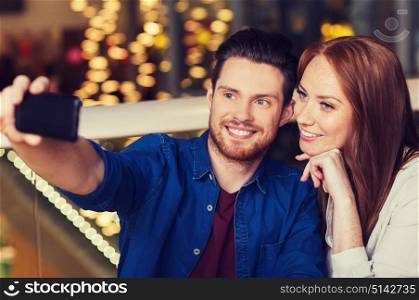 leisure, technology, date, people and holidays concept - happy couple taking selfie by smartphone at restaurant. couple taking selfie by smartphone at restaurant