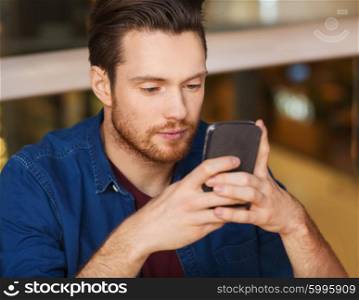 leisure, technology, internet addiction, lifestyle and people concept - man with smartphone reading message at restaurant
