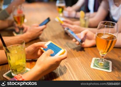 leisure, technology, lifestyle and people concept - close up of hands with smartphones messaging at restaurant