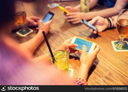 leisure, technology, lifestyle and people concept - close up of hands with smartphones messaging at restaurant