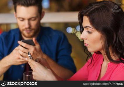 leisure, technology, lifestyle and people concept - couple with smartphones dining at restaurant