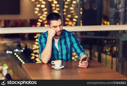 leisure, technology, lifestyle and people concept - man with smartphone and coffee at restaurant. man with smartphone and coffee at restaurant