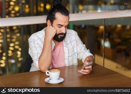 leisure, technology, lifestyle and people concept - man with smartphone and coffee at restaurant