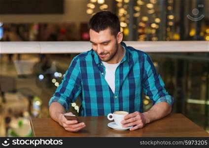 leisure, technology, lifestyle and people concept - smiling man with smartphone and coffee at restaurant
