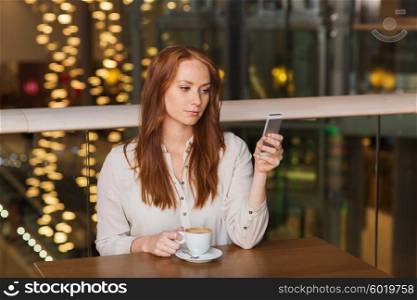 leisure, technology, lifestyle and people concept - woman with smartphone and coffee at restaurant